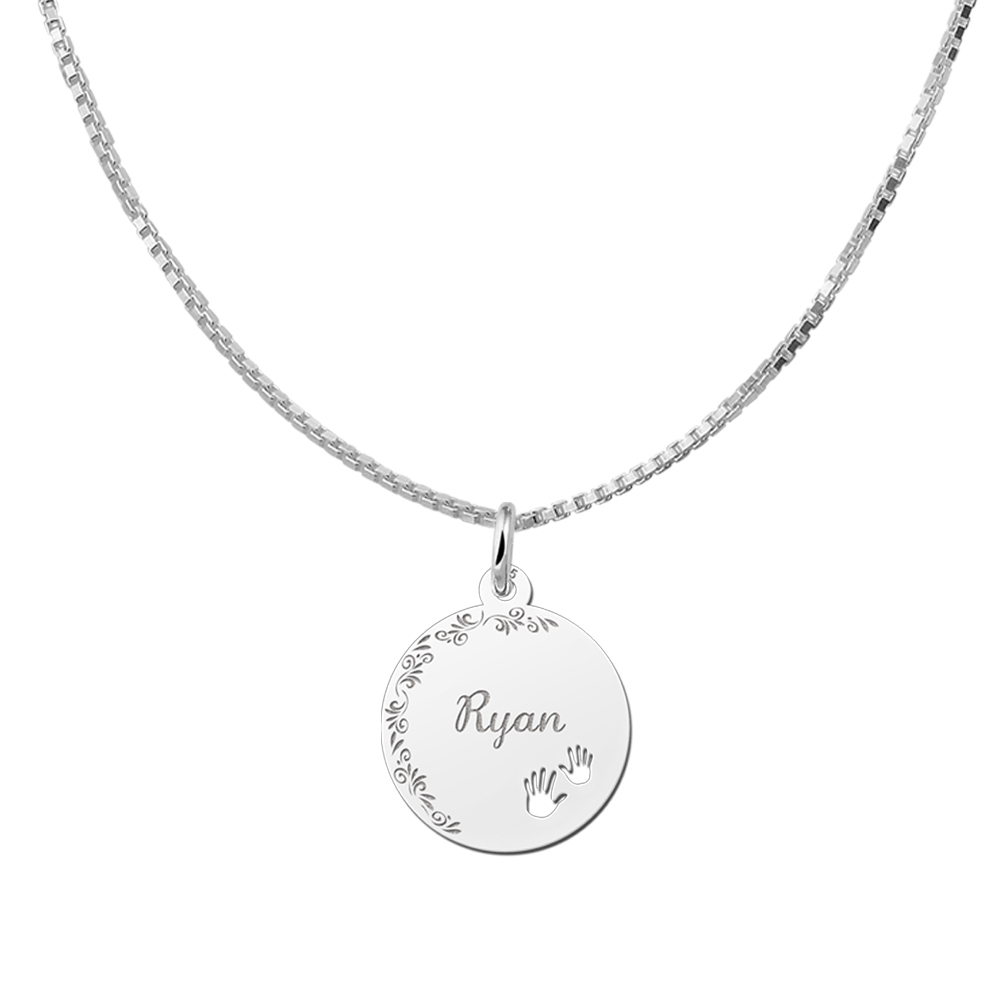 Colgante de plata con borde floral y manos de bebé